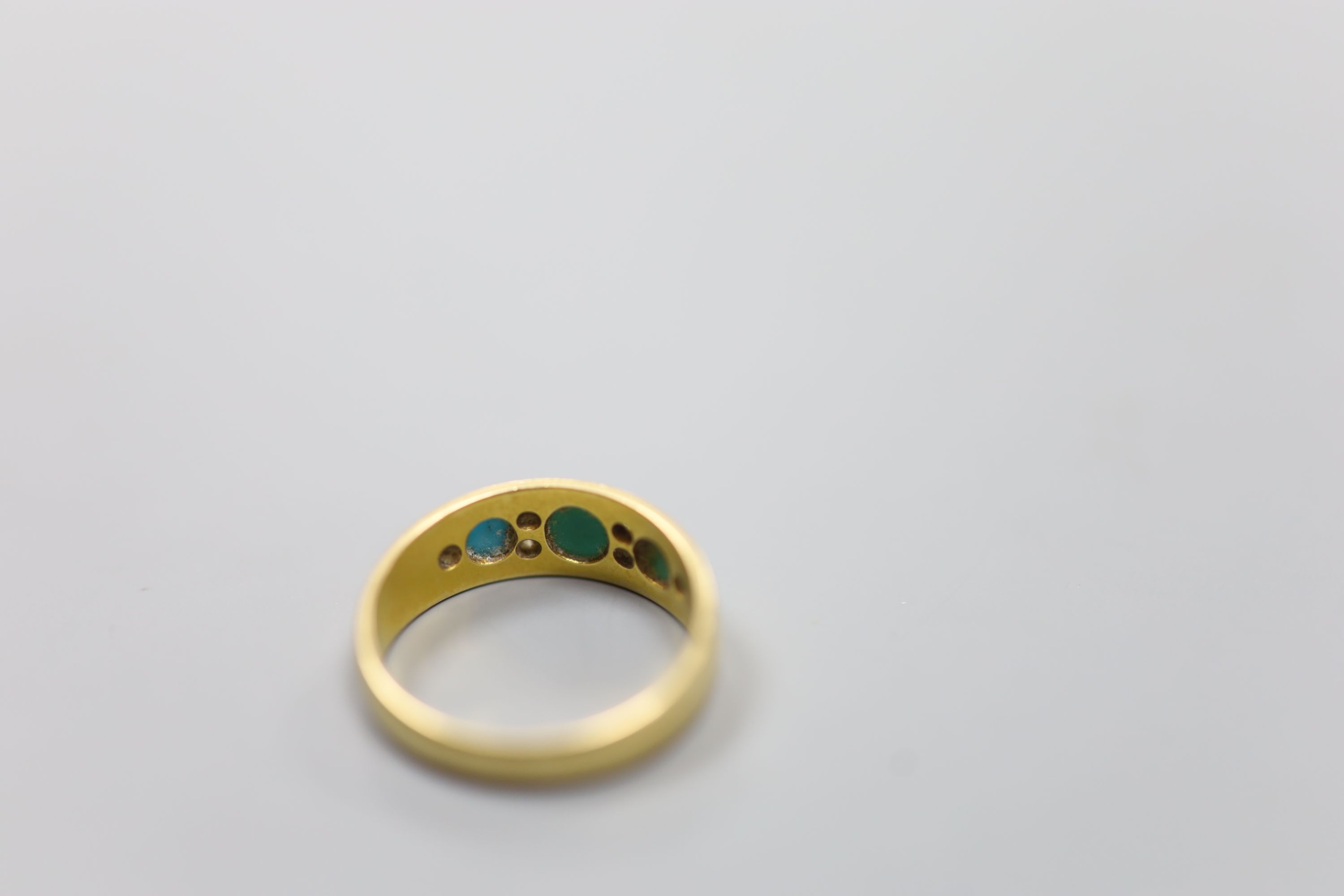 An early 20th century 18ct, three stone turquoise and six stone diamond chip set ring, size M/N, gross 4 grams.